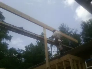 Carpenter setting a ridge beam over a new addition frame — Ice Dam Removal by Roofing Brothers in Elburn