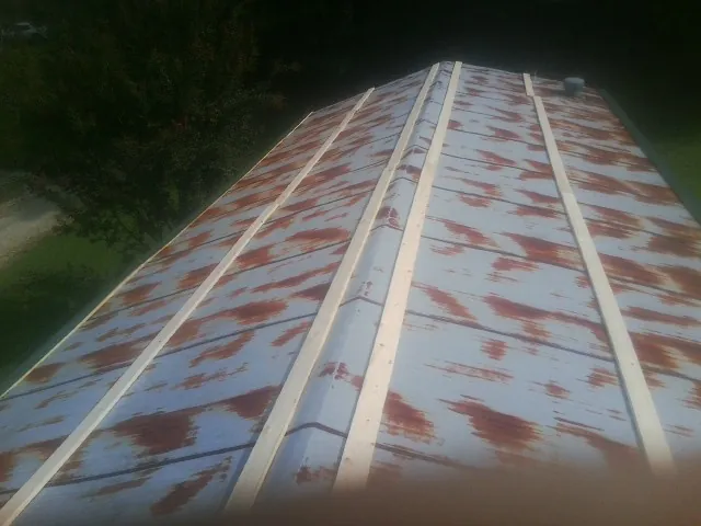Rusted metal roof panels with new wood purlins before replacement — Storm Damage Roof Repair in Elburn by Roofing Brothers