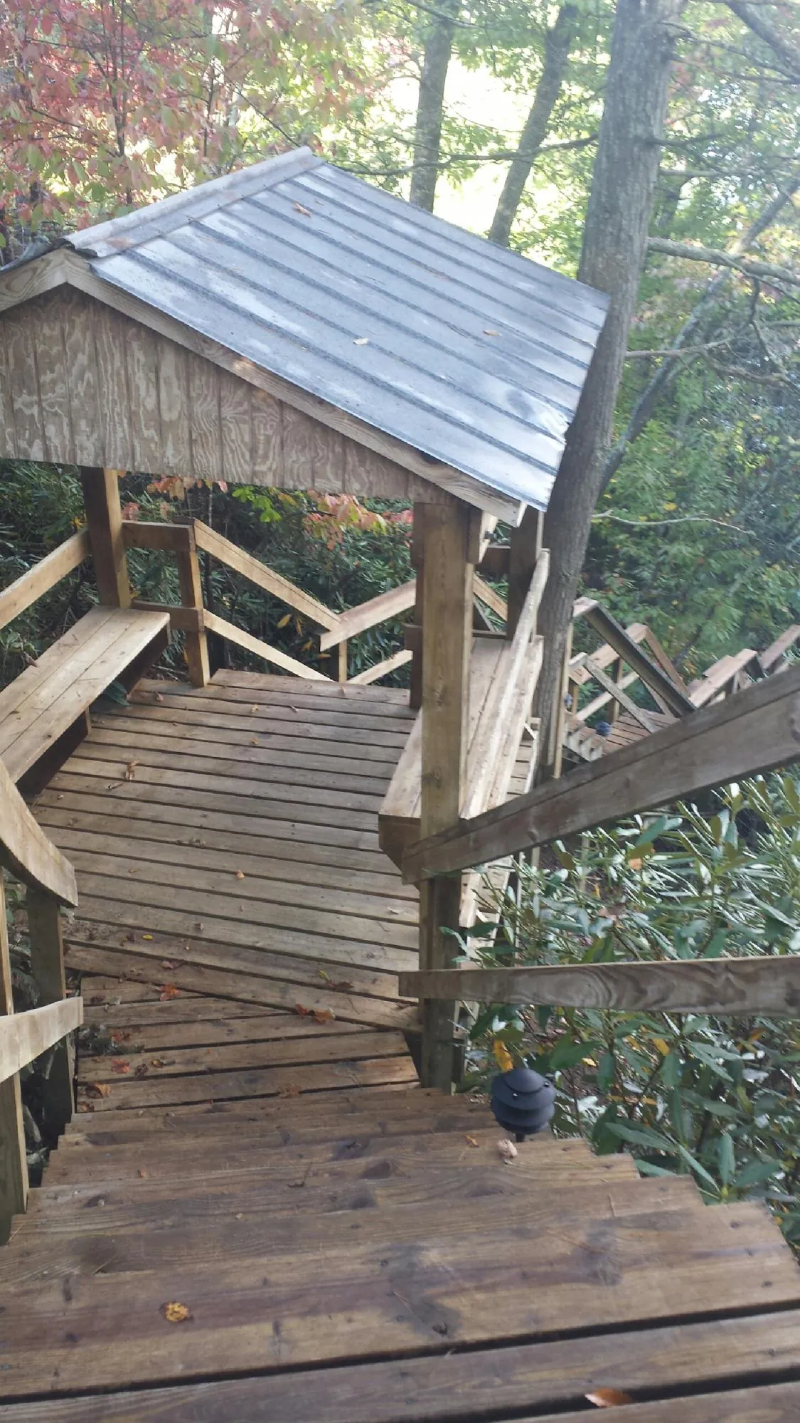 Metal roofed shelter over wooden steps on a wooded walkway — Skylight Repair & Installation work by our crew in Elburn