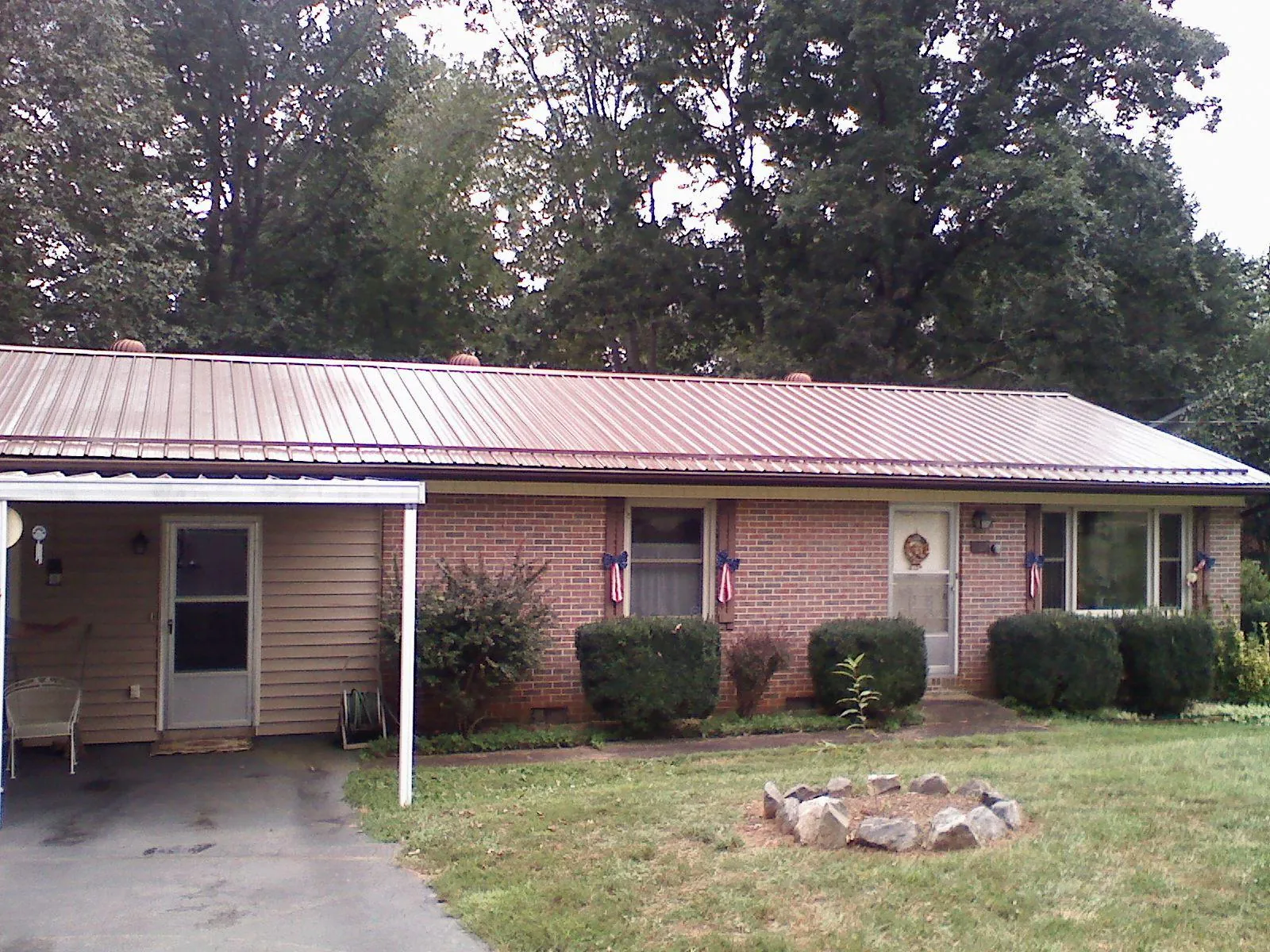 Bronze metal roof and carport on a brick ranch home — Roof Repair work by our crew in Elburn