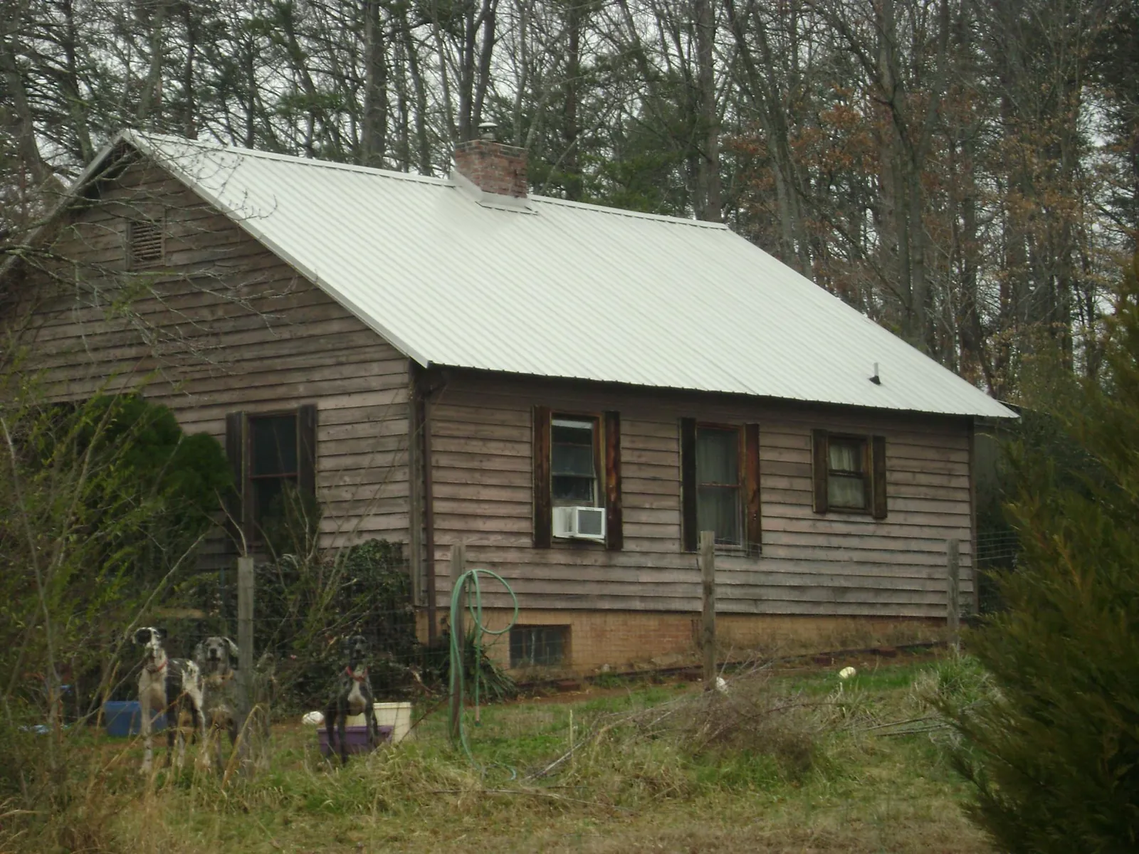 White metal roof on an old wood sided farmhouse, from a Metal Roof Installation job in Elburn